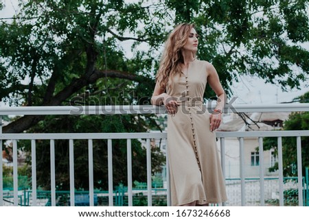 portrait of a beautiful fashionable woman in a gray dress on a walk