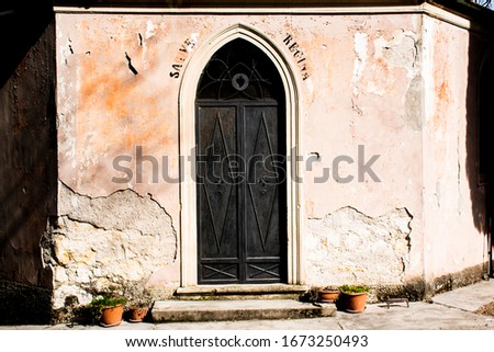 black metal door with engraved heart and religious writing