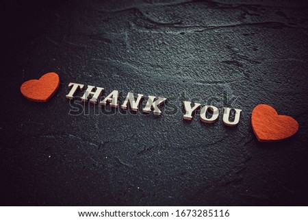 Word Thank You by wooden letters on black background