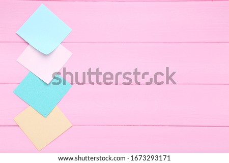 Paper sticky notes on pink wooden table