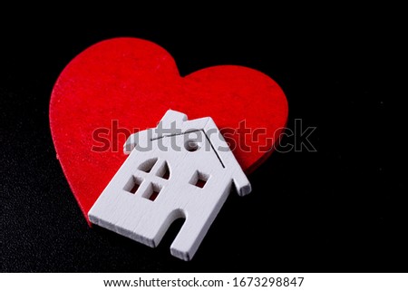 Wooden house with a red heart on a black background