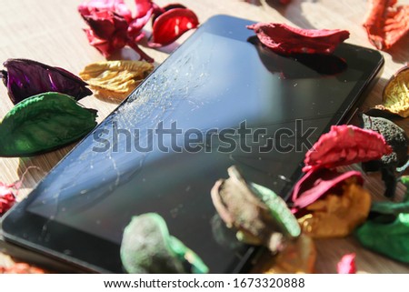 Cell phone with a broken screen and flower decoration