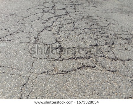 Close up of old cracked asphalt. Urban road with damaged asphalt, texture, backgroud.