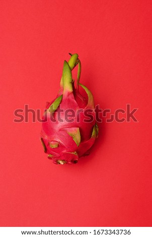 Beautiful tropical exotic dragon fruit pitahaya on the red background isolated picture top view flat lay closeup. Clolorful minimalistic fresh healthy food. Summer vacation tasty