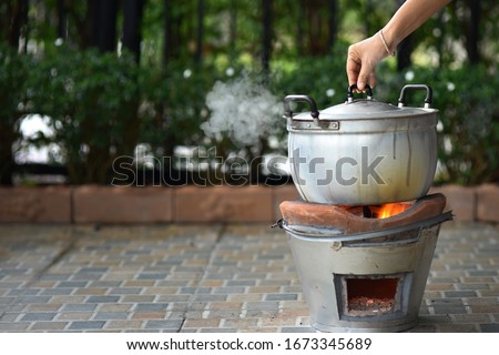 Cooking in pot. steam over the pot on outdoor background Royalty-Free Stock Photo #1673345689
