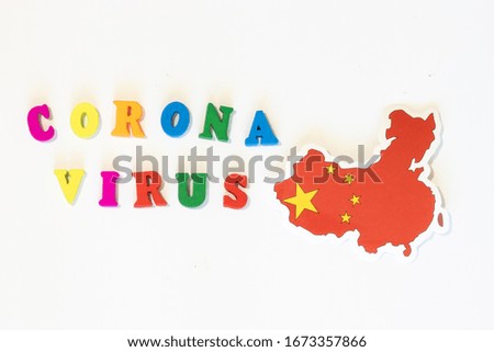 Chinese national flag on a white background with the inscription Corona virus made with letter board. Coronavirus is a pandemic virus originating in China.