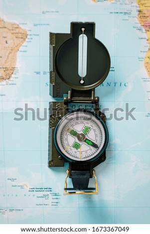 Detail of a compass camera on a world map. Concept adventure travel and orientation in the mountains.