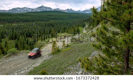 UTV Races Across Mountain Landscape  Royalty-Free Stock Photo #1673372428