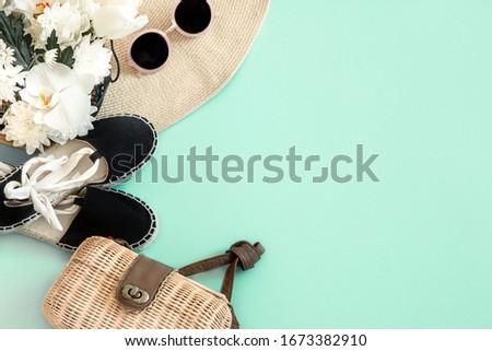 Colorful summer female fashion outfit flat-lay. A large wicker hat, with a bag and sunglasses. Summer fashion or holiday travel concept