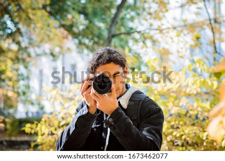 Ameteur photographer taking pictures in city park, admiring beauty of autumn nature