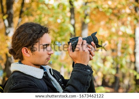 Taking pictures outdoor. Beginner photographer taking photos of nature in the park