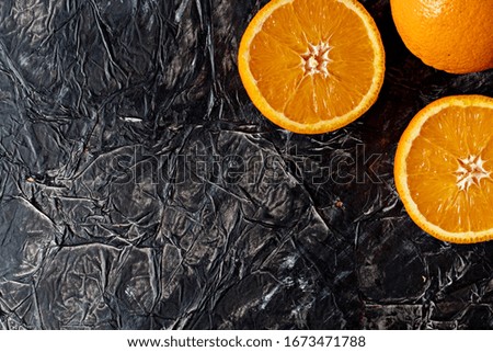 Fresh fruit on dark stone background. Oranges and apple. Top view - Image