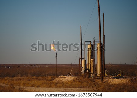 Permian Basin Gas Flare - Burning excess natural gas at a crude oil storage site is a common practice when gas prices deem it uneconomical to transport the gas to market. Royalty-Free Stock Photo #1673507944