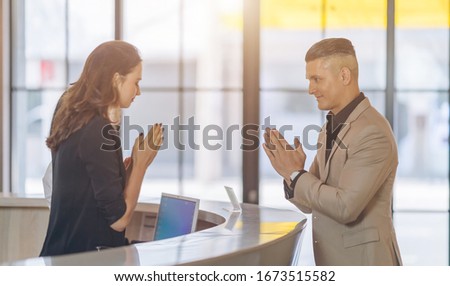 social distance Greetings female receptionist at counter in hotel