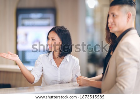 receptionist at counter area,Tourist register in hotel