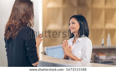 social distance Asia Greetings female receptionist at counter in hotel