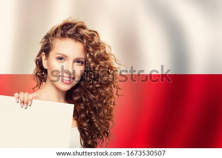 Cute young woman showing white paper on the Poland flag background. Travel and learn polish language concept Royalty-Free Stock Photo #1673530507