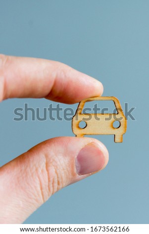 Car insurance concept. Protection of car (concept). Hand holding car model on gray background. vertical photo