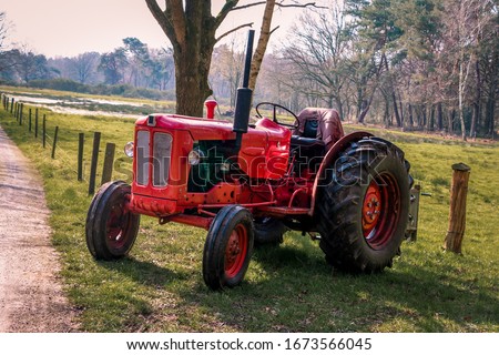 Old red vintage tractor on the land in the beautiful landscape of Drenthe near Havelte	
 Royalty-Free Stock Photo #1673566045