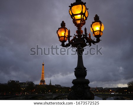 Historic streetlight in front of the illuminated Eiffel tower