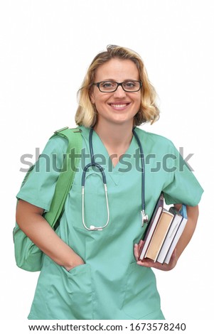 Young female nurse or intern surgeon in glasses and a green uniform with books and bag smiling looks into the camera isolated on a white background.