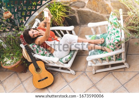 Beautiful Woman Playing Guitar Outdoors. Spanish Woman Playing Guitar with her Dog. Playing Spanish Guitar. Lifestyle Concept.