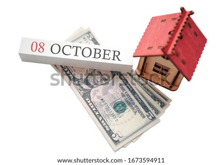 Money and red home with calendar. The concept of financial independence and the scheduled start date for October 8