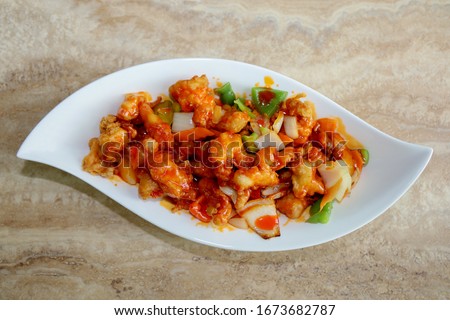 Sweet and sour chicken on a white platter. 