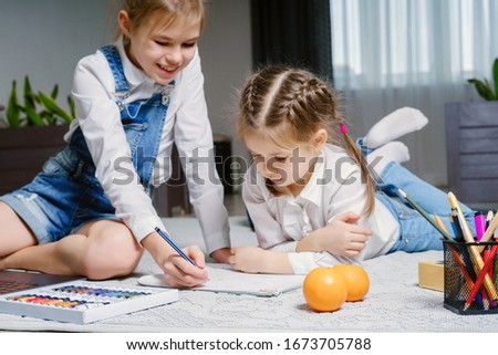 Close-up of children drawing lying on the floor in the living room
