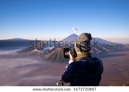 photographer taking photo on the top of mountain to take a sunrise photo for Bromo volcano, Landscape of Bromo volcano Java island, Indonesia