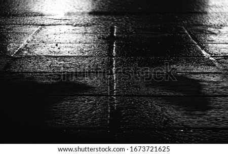night photography concrete tile high definition. wet asphalt after rain. black and white background.