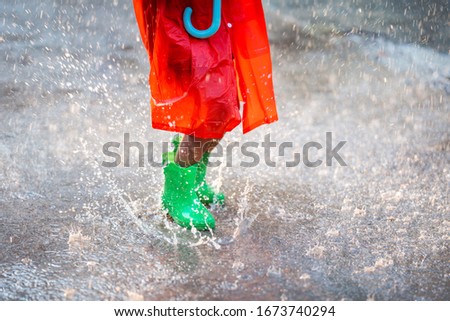 Asian girl is wearing green shoes. She jumps and is raining.