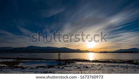 Sunrise over norwegian fjord. Nature snowy landscape in the sunrise