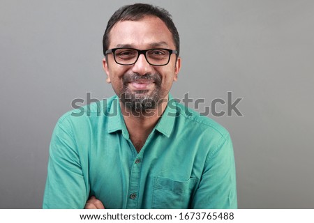 Portrait of a happy middle aged man of Indian ethnicity Royalty-Free Stock Photo #1673765488
