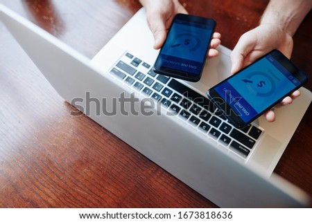Two business people using mobile application to transfer money from one banking account to another