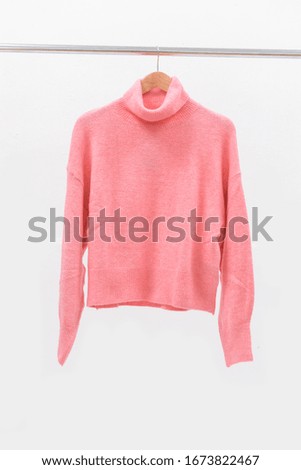 Pink female knitted woolen sweater on a hanger


