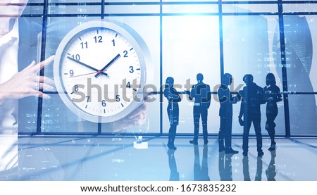 Silhouettes of business people working together in panoramic office with double exposure of woman holding big clock. Concept of time management and teamwork. Toned image Royalty-Free Stock Photo #1673835232