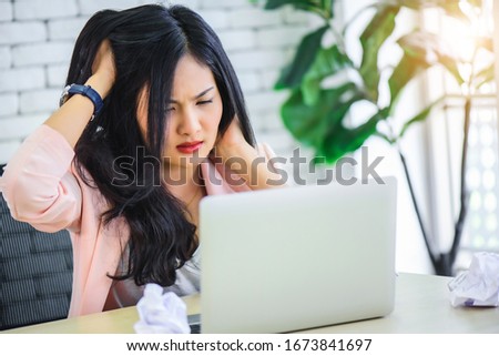 Young Asian woman stress with her frustrated or unsuccessful business online shopping at office. Boring or unhappy business office life concept.