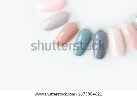 Nail polish samples in different bright colors. Colorful nail lacquer manicure swatches. Top view of nail art wheel palette. Royalty-Free Stock Photo #1673884621