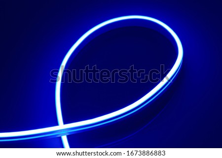 Flexible blue LED neon strip on black background.