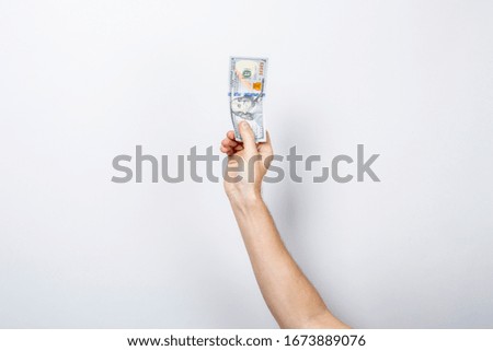 Female hand holds money on a white isolated background. Concept is rich, wealth, buy, pay, tax. Banner