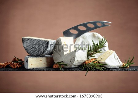 Various soft cheeses with walnuts and rosemary. Copy space.