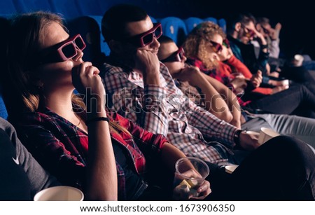 People in a movie theater are sitting and watching a boring movie in 3D glasses. Stock photo of a group of people in the cinema.