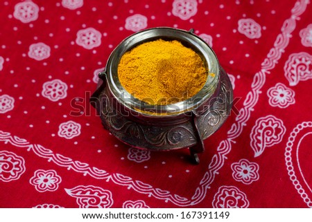Curry powder in small vintage bowl on red cloth