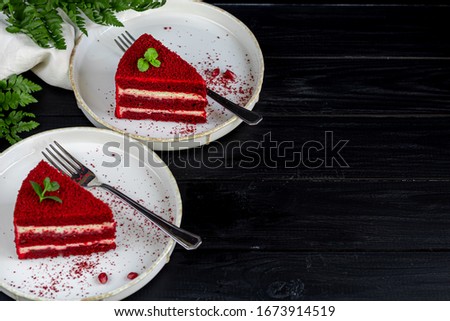 Cake Red velvet on two white plates, two servings. On a black background. Birthday, holidays, sweets.