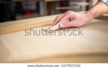 Close up of abrasive paper polishing a wooden board Royalty-Free Stock Photo #1673921326