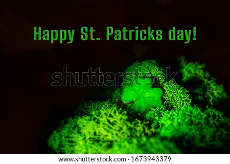 St. Patrick day background. Lucky clover in natural moss in dark. Top view, copy space. Happy Saint Patricks day inscription.