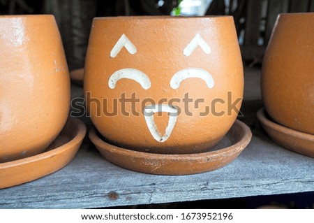 Flowerpot with faces showing feelings