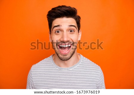 Closeup photo of crazy funky energetic guy open mouth best excited feelings emotions listen good news wear casual striped t-shirt isolated bright orange color background Royalty-Free Stock Photo #1673976019