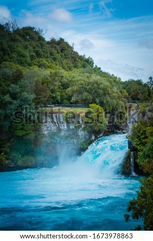 View over Huka Falls amongst rocks and trees. Taupo, New Zealand Royalty-Free Stock Photo #1673978863